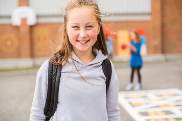 Eine Schülerin am ersten Schultag auf dem Schulhof — Stockfoto