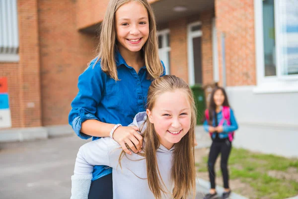 Ein paar nette Kinder im Hintergrund der Schule, die Spaß haben — Stockfoto