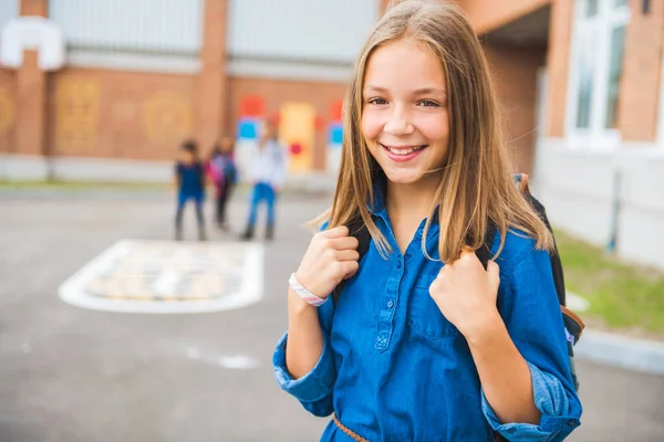Une élève écolière sur le terrain de jeu le premier jour de classe — Photo