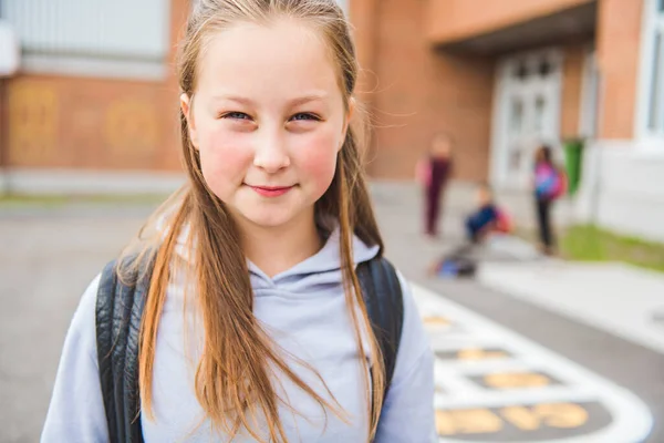 Eine Schülerin am ersten Schultag auf dem Schulhof — Stockfoto