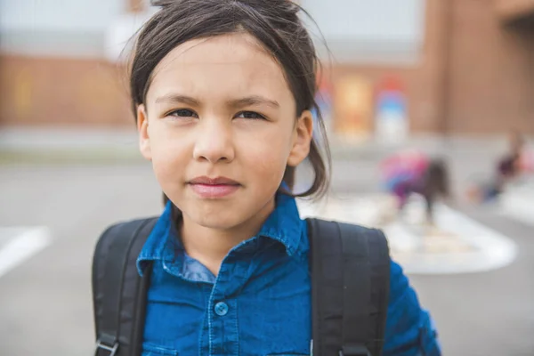 Une élève écolière sur le terrain de jeu le premier jour de classe — Photo