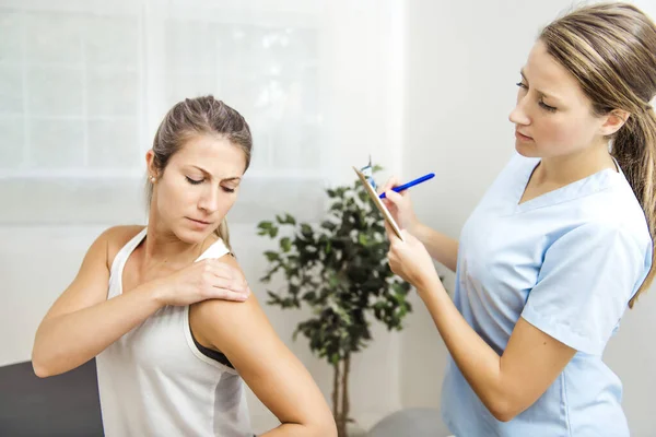 A Modern rehabilitation physiotherapist at work with client — Stock Photo, Image