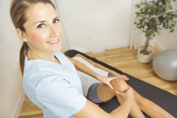 A Modern rehabilitation physiotherapist at work with client. Working on shoulder. — Stock Photo, Image