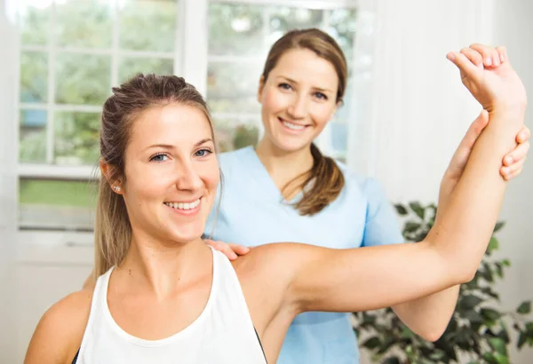 A Modern rehabilitation physiotherapist at work with client — Stock Photo, Image
