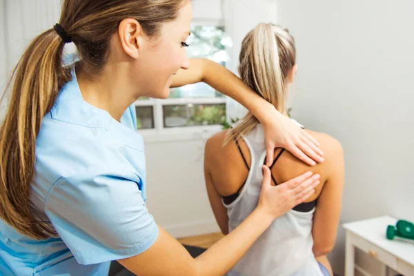 A Modern rehabilitation physiotherapist at work with client — Stock Photo, Image