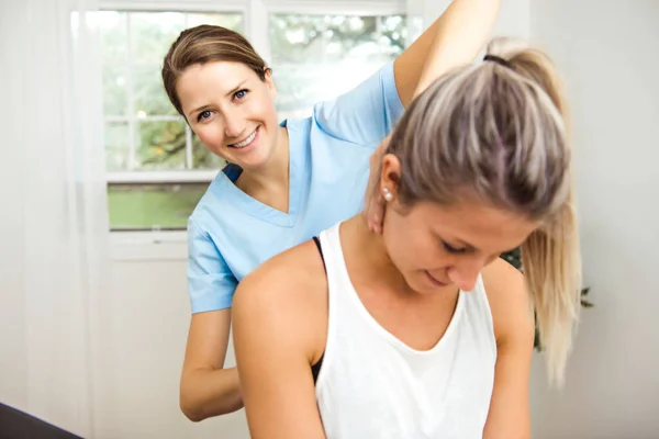 A Modern rehabilitation physiotherapist at work with client — Stock Photo, Image