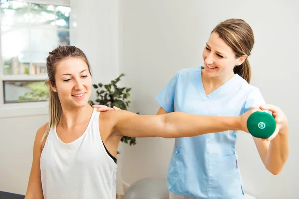 Ein moderner Reha-Physiotherapeut bei der Arbeit mit dem Klienten — Stockfoto