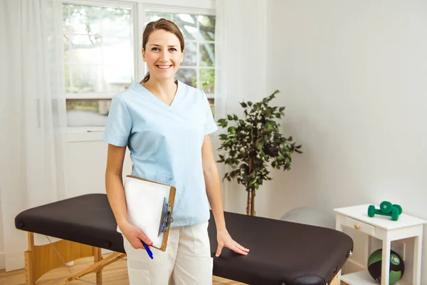 Junge Physiotherapeutin mit Klemmbrett im Reha-Zentrum — Stockfoto