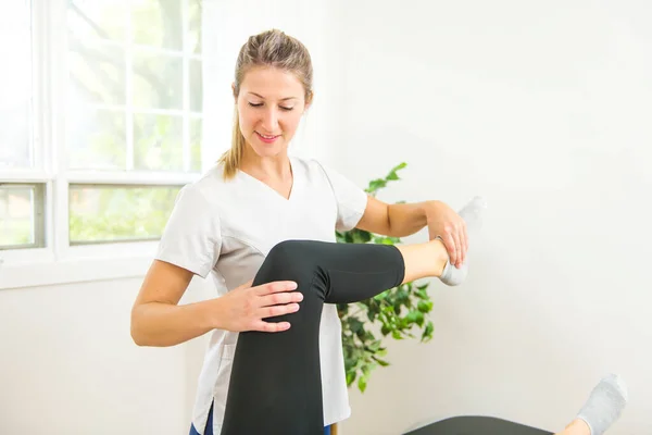 Ein moderner Reha-Physiotherapeut bei der Arbeit mit dem Klienten. Arbeit an der Schulter. — Stockfoto