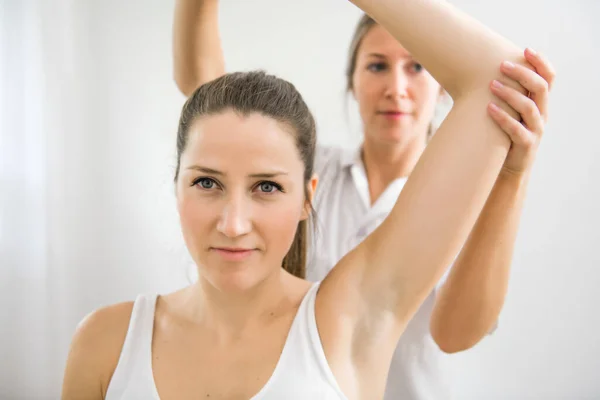 Ein moderner Reha-Physiotherapeut bei der Arbeit mit dem Klienten — Stockfoto