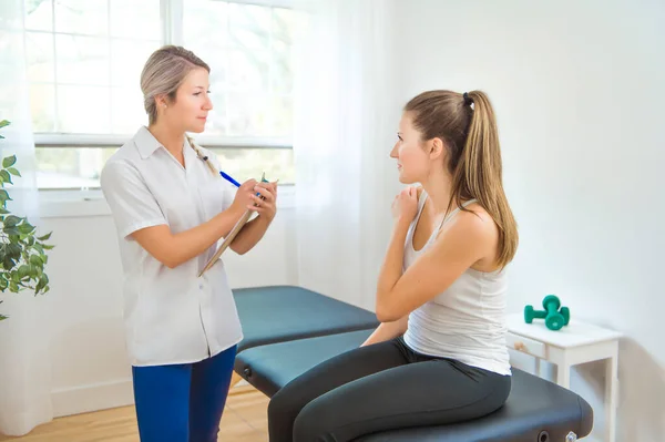 A Modern rehabilitation physiotherapist at work with client — Stock Photo, Image