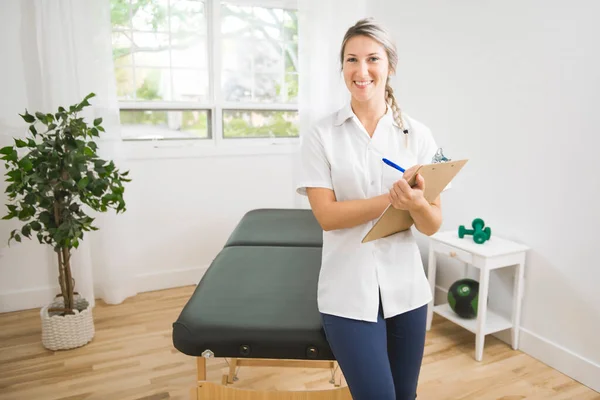 Junge Physiotherapeutin mit Klemmbrett im Reha-Zentrum — Stockfoto