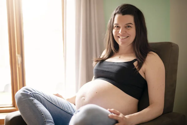 Una hermosa madre embarazada en la habitación del bebé —  Fotos de Stock