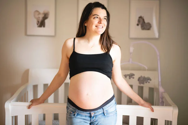Una bella madre incinta sulla stanza del bambino — Foto Stock