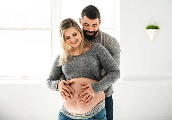Беременная женщина с мужем чувствует себя счастливой дома — стоковое фото
