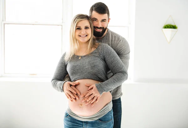 Беременная женщина с мужем чувствует себя счастливой дома — стоковое фото