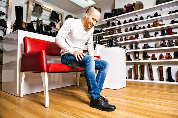 Egy férfi új cipőt keres a cipőboltban. — Stock Fotó
