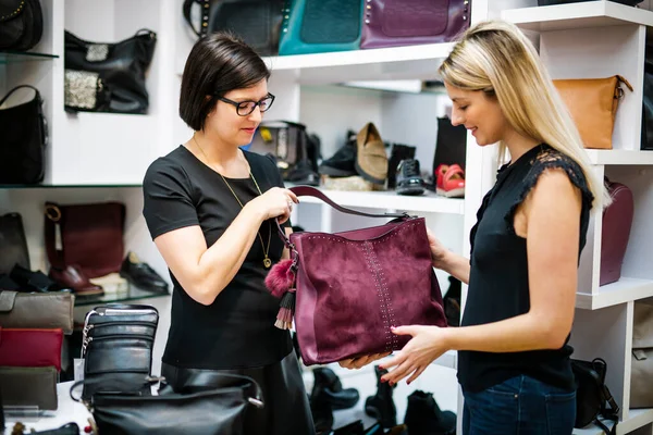 Молодая женщина покупатель выбирает сумку, соответствующую ее случайный стиль — стоковое фото