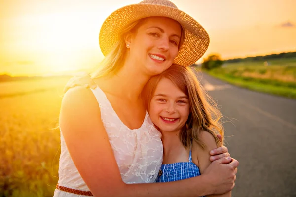 Happy family at sunset. Mother and daughter having fun and playing in nature — Stock Photo, Image