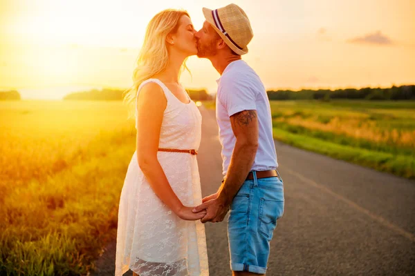 Pareja feliz al atardecer. Hombre y mujer divirtiéndose jugando en la naturaleza —  Fotos de Stock