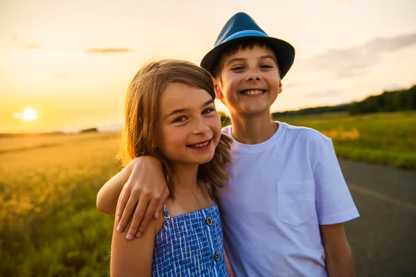 Dvě děti bratr a sestra na seně pole při západu slunce — Stock fotografie