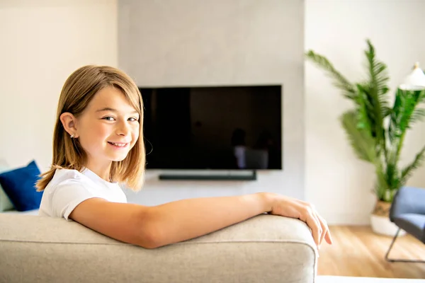 リモコンを持ってテレビ番組を見ている女の子 — ストック写真