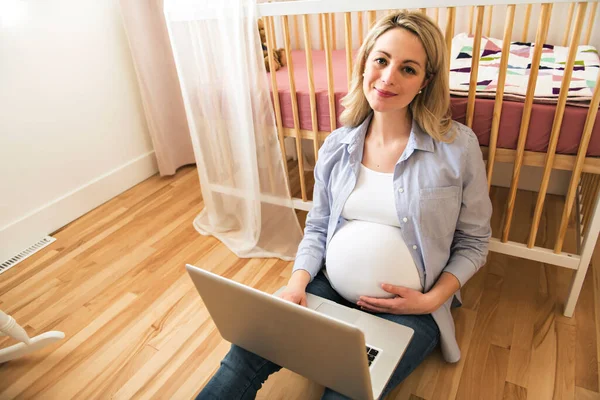 Attraente giovane donna incinta con computer portatile — Foto Stock