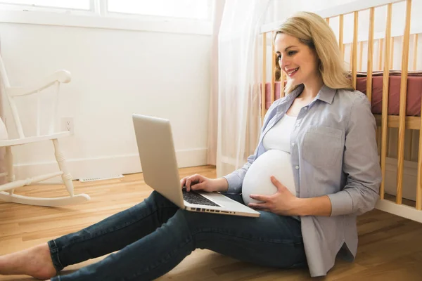 Attraente giovane donna incinta con computer portatile — Foto Stock