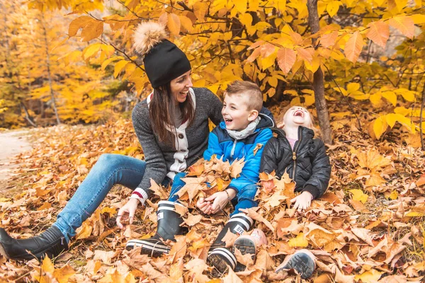 Um retrato de uma jovem família no parque de outono — Fotografia de Stock