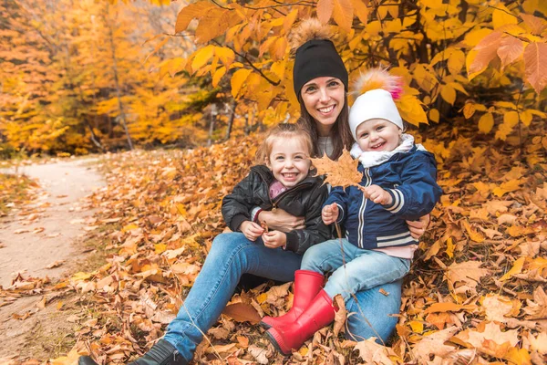 Een portret van een jong gezin in het herfstpark — Stockfoto
