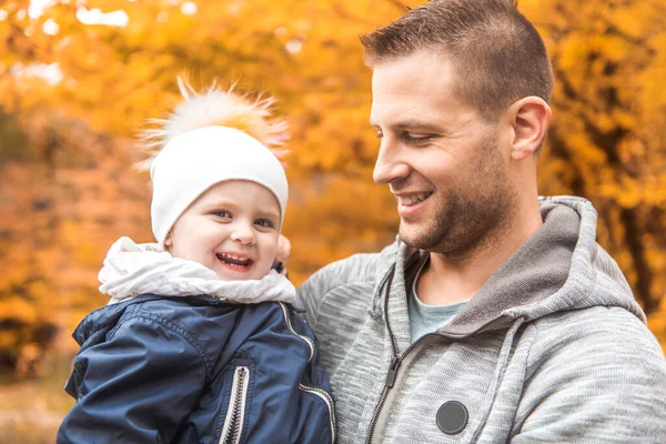 Ritratto di un padre con bambino nel parco autunnale — Foto Stock