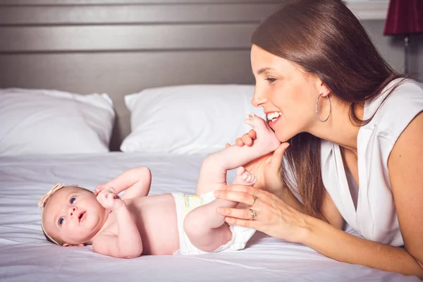 Una madre felice con bambino sul letto — Foto Stock