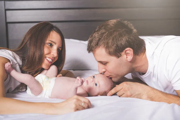 Madre padre e bambino su un letto bianco. — Foto Stock