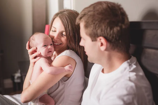 Madre padre e hijo bebé en una cama blanca. — Foto de Stock