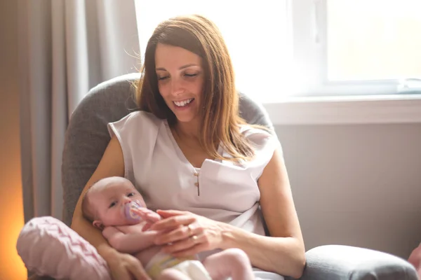 Ung mor håller i sitt nyfödda barn. Mamma ammar barnet. — Stockfoto