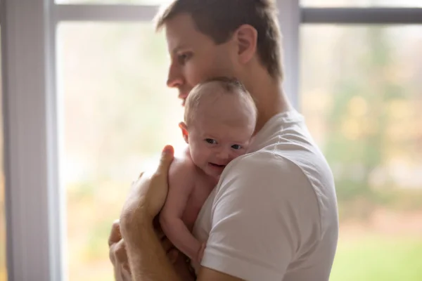 Pai da família feliz com bebê recém-nascido na frente da janela — Fotografia de Stock