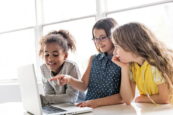 Grupa ciekawskich dzieci oglądających rzeczy na ekranie laptopa — Zdjęcie stockowe
