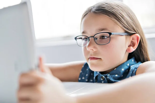 Uma criança bonita usando tablet na escola — Fotografia de Stock