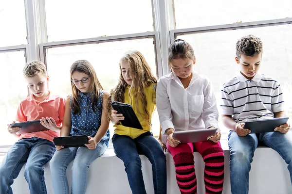 Grupa ciekawskich dzieci oglądających rzeczy na ekranie tabletu — Zdjęcie stockowe