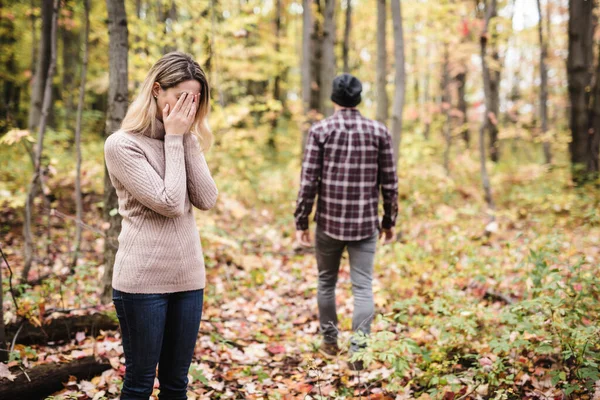 Una mujer triste en el parque durante el tiempo otoñal escondiéndose cara en mano, sintiéndose terriblemente deprimida. — Foto de Stock