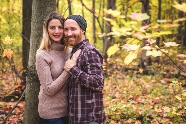 Unga par förälskade i en park på en höstdag — Stockfoto