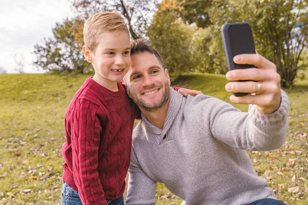 Family father taking selfie by smartphone in autumn park — Stock Photo, Image