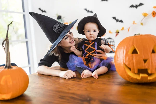 Rodina matka a dcera na kuchyňském stole připravena na Halloween s dýní — Stock fotografie