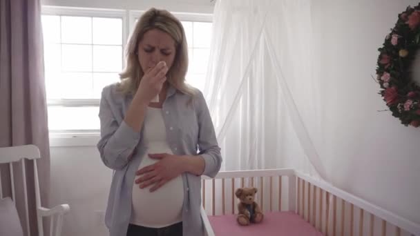 Pregnant woman sad near crib at home — Stock Video