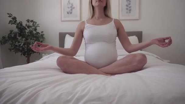 Pregnant woman on bed on yoga style — Stock Video