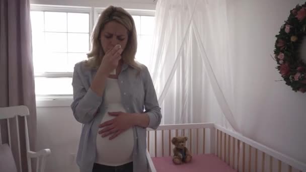 Pregnant woman sad near crib at home — Stock Video