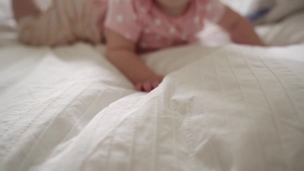 Nice e bonito bebê leigos em roupa de cama branca. — Vídeo de Stock