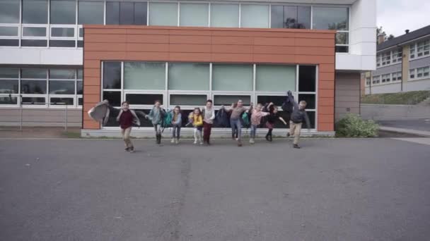 Okul bittiği için mutlu koşan bir grup çocuk. — Stok video