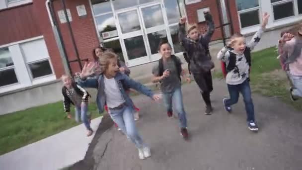 Grupo de niños en el fondo de la escuela se divierten al final de la clase — Vídeos de Stock