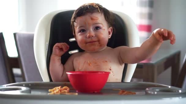 Anak gadis, makan spaghetti untuk makan siang dan membuat berantakan di rumah di dapur — Stok Video